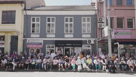 Tourist-crowds-sit-waiting-for-Bulgarian-rose-festival-parade