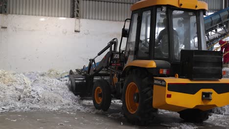 Recycling-is-converting-the-waste-stock,-JCB-Machine-unloading-waste-stock-paper-materials