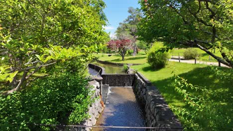 Ryontonji-Tempel-In-Hamamatsu,-Japan,-Künstlicher-Wasserfall-Inmitten-üppiger-Vegetation,-Bunter-Blumen-Und-Verschiedener-Bäume