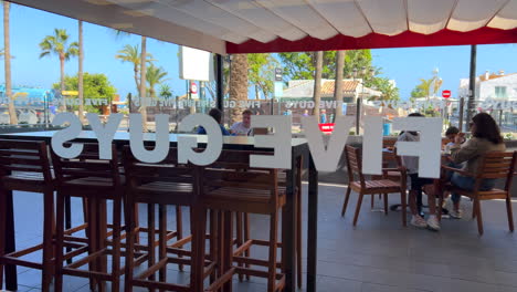 Five-Guys-Fastfood-Burger-Restaurant-In-Puerto-Banus,-Marbella,-Spanien,-Leute-Essen-Drinnen,-4k-Aufnahme