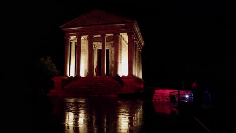 Few-visitors-at-Greco-Roman-Garni-Temple-on-dark-wet-night-in-Armenia