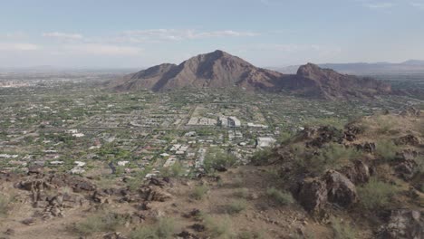 Aerial-shot-of-Mummy-mountain-and-revealing-Paradise-valley-of-Arizona-in-USA-and-Camelback-mountain-at-background