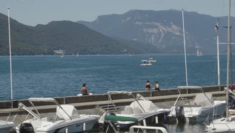 Die-Leute-Beobachten-Die-Skyline-Im-Seehafen-In-Der-Alpinen-Berglandschaft,-Marinesegel