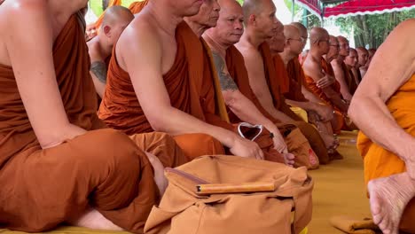 Grupo-De-Monjes-Sentados-Y-Rezando-En-Vesak,-Vista-De-Cerca