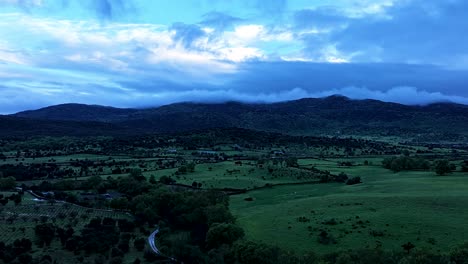 Vuelo-De-Drones-En-El-Valle-Del-Tiétar,-Al-Fondo-Se-Ven-Las-Montañas-Con-Nubes-Colgando-En-Las-Cumbres,-Corren-A-Gran-Velocidad-Por-El-Hiperlapso-Icono-De-Validado-Por-La-Comunidad