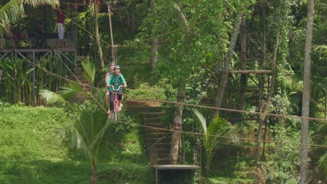 Una-Pareja-Disfruta-De-Un-Emocionante-Paseo-En-Una-Bicicleta-Tándem-Suspendida-Sobre-Las-Exuberantes-Terrazas-De-Arroz-De-Tegallalang,-Bali,-Indonesia.