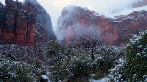 Toma-Estática-De-Las-Montañas-De-Roca-Roja-En-El-Parque-Nacional-Zion-Mientras-Cae-La-Nieve-Y-Las-Nubes-Pasan