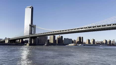 A-picturesque-view-of-the-Manhattan-Bridge-spanning-the-East-River,-with-the-backdrop-of-New-York-City's-skyline,-capturing-the-elegance-and-engineering-prowess-of-this-iconic-structure