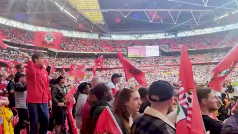 Aficionados-Al-Fútbol-Sosteniendo-Las-Banderas-De-Sus-Equipos.