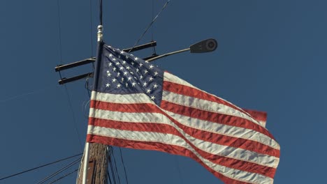 American-flag-blowing-in-wind-in-front-of-blue-sky-for-4th-of-July