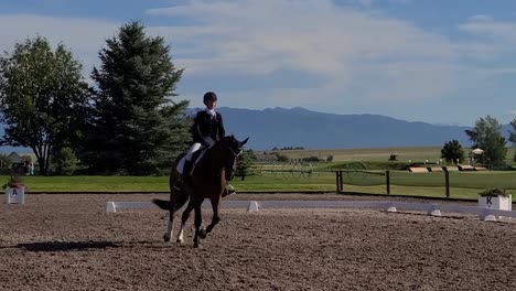 A-young-lady-horseback-riding-in-a-dressage-horse-show-in-Montana-with-Glacier-National-Park-in-the-background