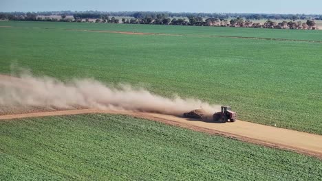 Clouds-of-dust-come-off-a-tractor-and-small-road-grader-on-dirt-farm-road