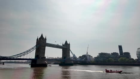 Tower-Bridge-Von-Tower-Wharf-Aus-Betrachtet,-Mit-Vorbeifahrenden-Booten-Auf-Der-Themse-An-Einem-Sonnigen-Morgen