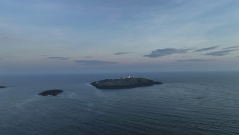 Distant-aerial-approach-to-Marsteinen-lighthouse-with-hazy-sunset-horizon-background