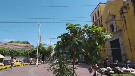 Historic-yellow-church-against-a-blue-sky-in-Cartagena-with-lush-greenery-around