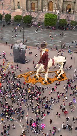 Giant-skeleton-for-Day-of-the-Dead-in-historic-center-of-Mexico-City,-vertical-aerial-view