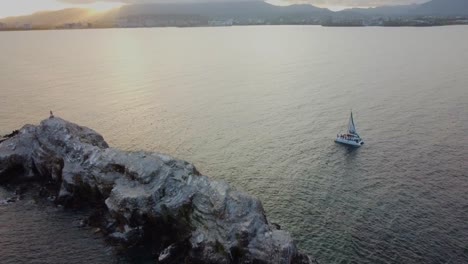 Flock-of-birds-perched-on-rocky-coastline-during-golden-sunset-in-Venezuela