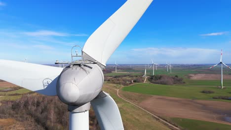 drone-footage-of-wind-turbines-in-a-wind-farm-generating-green-electric-energy-on-a-wide-green-field-on-a-sunny-day,-in-Taurage,-Lithuania