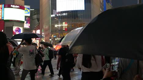 Turistas-Caminando-Por-El-Cruce-De-Shibuya-En-Una-Noche-Lluviosa