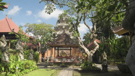 Ubud-Palace-Architecture-Wide-Angle-Reveal-From-Behind-Ancient-Statues---Ornamented-Angkul-Doors-and-Pavilions,-Puri-Saren-Agung---historical-Balinese-Place,-Gianyar-Regency-of-Bali,-Indonesia---dolly