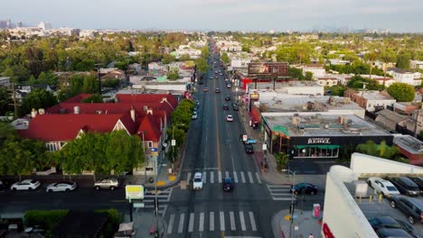 Drone-Flight-Over-Busy-West-Hollywood-Street-in-Daytime,-Melrose-Shopping-District-as-Seen-from-Above-on-Clear-Day