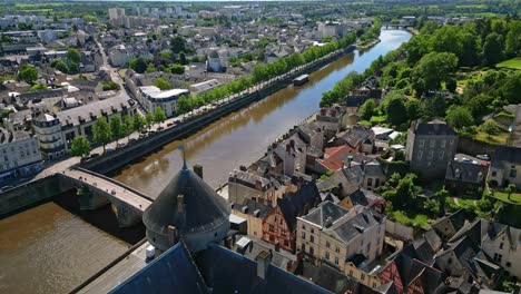 Drone-flying-over-Chateau-de-Laval-castle-along-Mayenne-river,-France