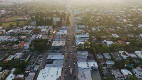 Tagsüber-Flug-über-Die-Sonnenbeschienene-Melrose-Avenue,-Drohne-Fliegt-Schnell-über-Eine-Belebte-Straße-In-West-Hollywood