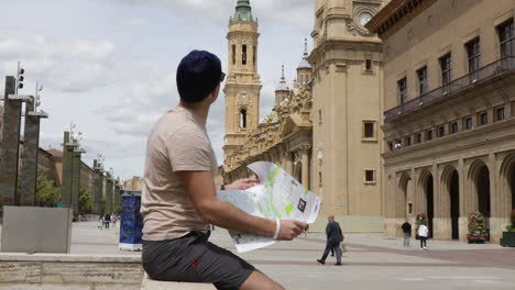 A-tourist-with-a-map-looks-at-the-Basilica-of-Our-Lady-of-the-Pillar-in-Zaragoza