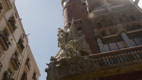 Vista-En-ángulo-Bajo-De-Una-Escultura-Histórica-En-La-Fachada-De-Un-Edificio-En-Barcelona,-España,-Que-Muestra-La-Arquitectura-Clásica