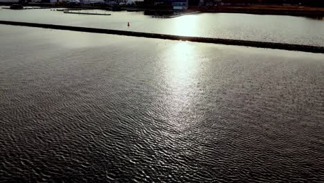 Brillante-Superficie-De-Agua-De-Mar-Con-Reflejos-Del-Sol-Al-Atardecer---Disparo-De-Drones