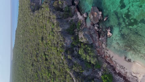 Vertical-aerial-view-of-turquoise-clear-water-with-tropical-landscape-island-in-Dominican-Republic