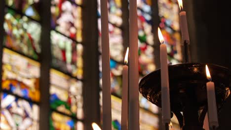 Candles-burning-in-front-of-stained-glass-at-St