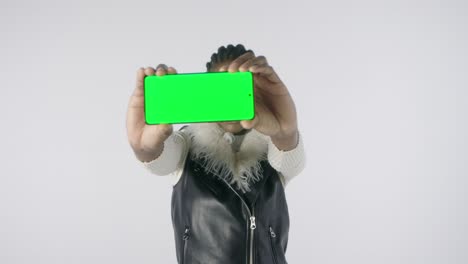 A-girl-shows-a-mobile-phone-on-a-green-screen-to-tell-something