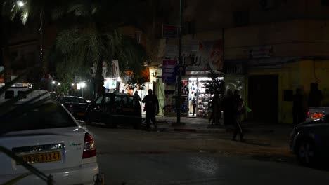 Ramadan-night-in-Ghardaia,-cars-and-pedestrians-passing-along