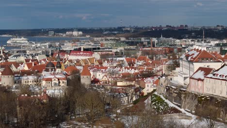 Drone-flyover-Tallinn-fortified-old-town,-reveal-historic-St-Olafs-Church