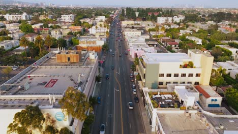 Flying-Over-Melrose-Avenue-in-Daytime,-Birds-Eye-View-of-Busy-Intersection-on-Iconic-Street-in-Los-Angeles-Shopping-District