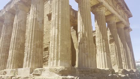 Close-shot-of-the-columns-of-an-ancient-Greek-building-Valle-dei-Templi-skyline