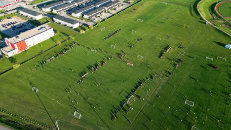 Aerial-drone-shot-of-a-group-of-children-playing-soccer-on-an-outdoor-football-field-in-winnipeg-Manitoba-canada