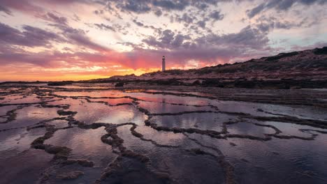 Wunderschöner-Zeitraffer-Sonnenuntergang-Im-Trafalgar-Leuchtturm-Mit-Felsigem-Muster-Im-Vordergrund-Und-Kleinen-Wasserteichen