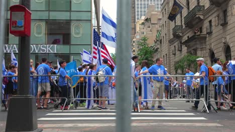 A-low-angle-view-of-the-Israel-Day-Parade-from-behind-metal-police-barricades-in-New-York-City-on-a-sunny-day