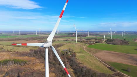 drone-footage-of-wind-turbines-in-a-wind-farm-generating-green-electric-energy-on-a-wide-green-field-on-a-sunny-day,-in-Taurage,-Lithuania