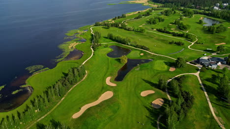 Drone-Aéreo-Hacia-Atrás-Disparado-Sobre-Un-Campo-De-Golf-Verde-Llamado-Ozo-Golf-Club-En-Riga,-Letonia-En-Un-Día-Soleado