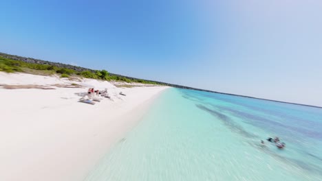 Drone-flight-over-luxury-sandy-beach-with-turquoise-water-in-sunlight