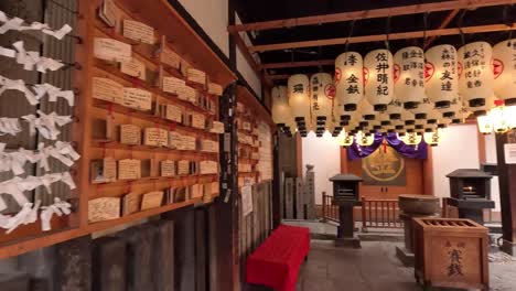 Tiras-De-Papel-De-La-Fortuna-O-mikuji-Y-Linternas-Japonesas-En-El-Templo-Hozen-ji-En-Osaka,-Japón