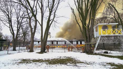 School-on-fire-being-extinguished-by-Canadian-firefighters,-thick-cloud-of-smoke,-Montreal-Canada