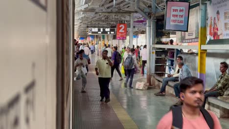 Los-Pasajeros-De-La-Estación-De-Tren-Se-Apresuran-Alrededor-De-Un-Tren-Detenido,-Visto-Desde-Su-Puerta.