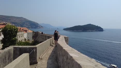 Visitors-strolling-along-the-ancient-City-Walls-of-Dubrovnik,-Croatia,-people-embrace-the-essence-of-tourism,-adventure,-and-discovery-in-one-of-Europe's-most-captivating-destinations