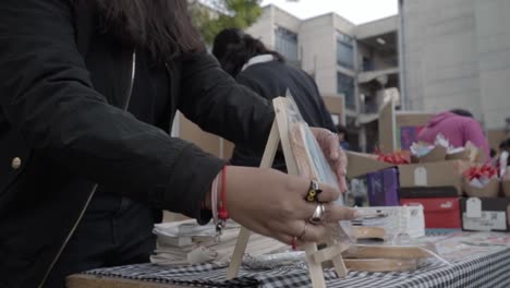 Young-Hispanic-women-place-their-products-for-sale-on-tables-at-an-entrepreneurship-fair