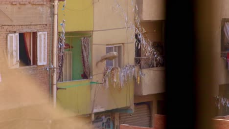 Window-view-to-apartment-house-with-balconies-in-poor-Cairo-area