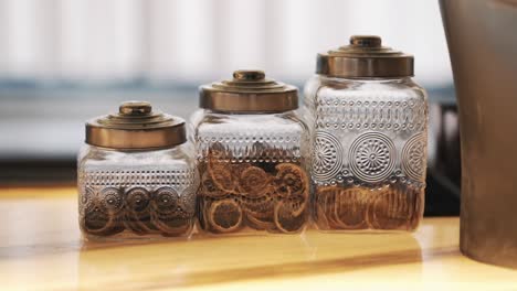 Elegant-table-display-with-three-intricate-glass-jars-filled-with-dehydrated-fruit-slices